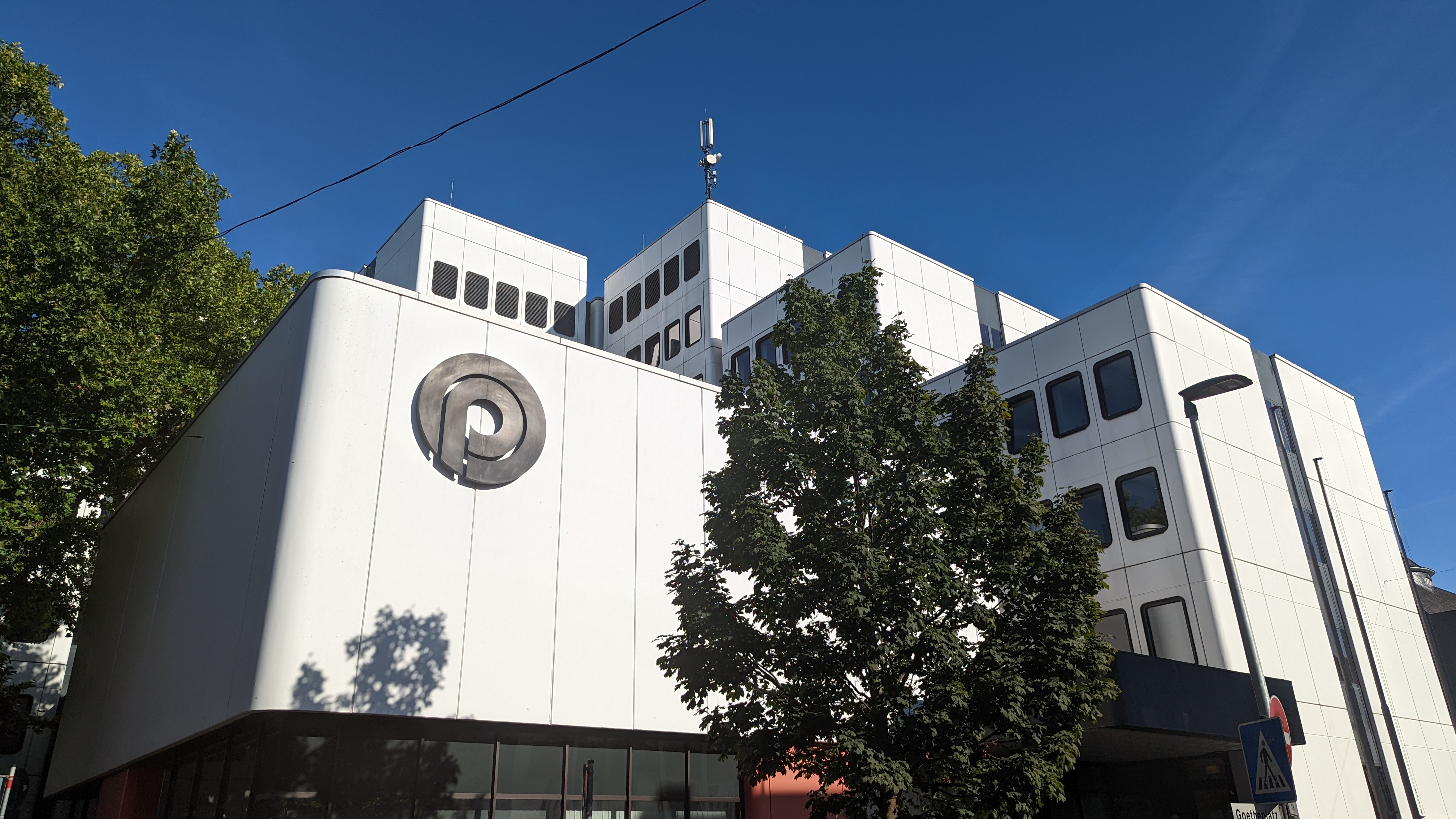 Verwaltungsgebäude Goetheplatz in Opladen im Sonnenschein. Gut zu sehen ist ein Logo, dass das Kürzel von Opladen enthält: OP