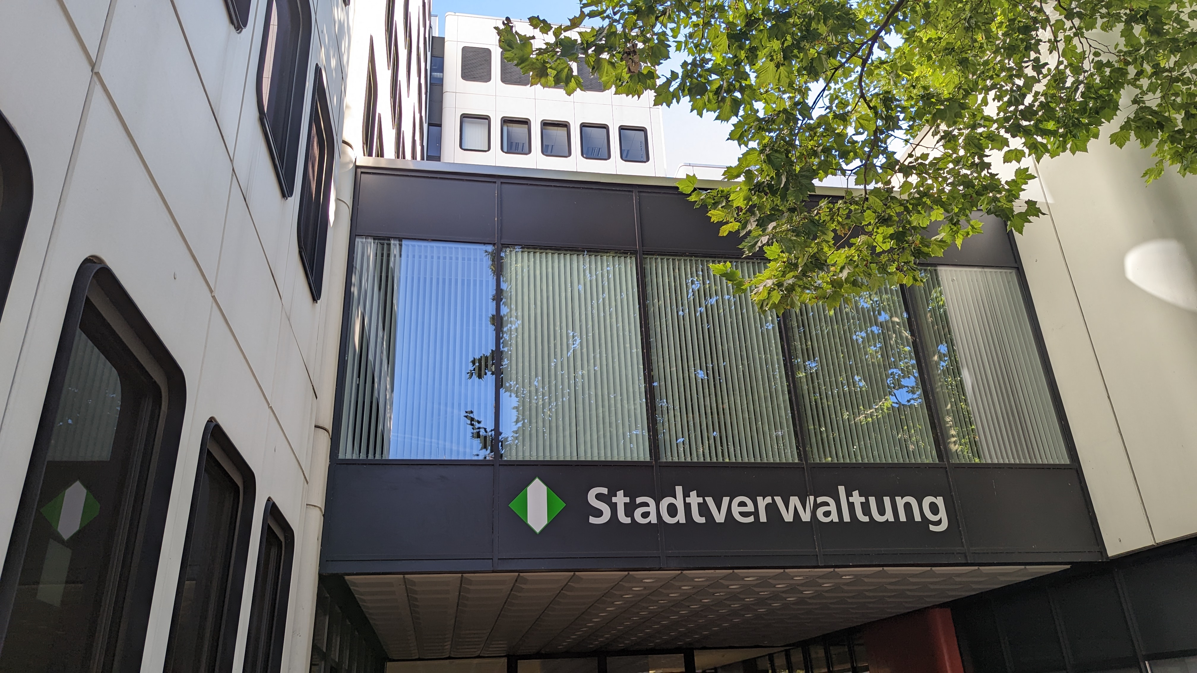 Eingang zum Verwaltungsgebäude Goetheplatz in Opladen. Über dem Haupteingang steht das Logo der Stadt und der Schriftzug "Stadtverwaltung".