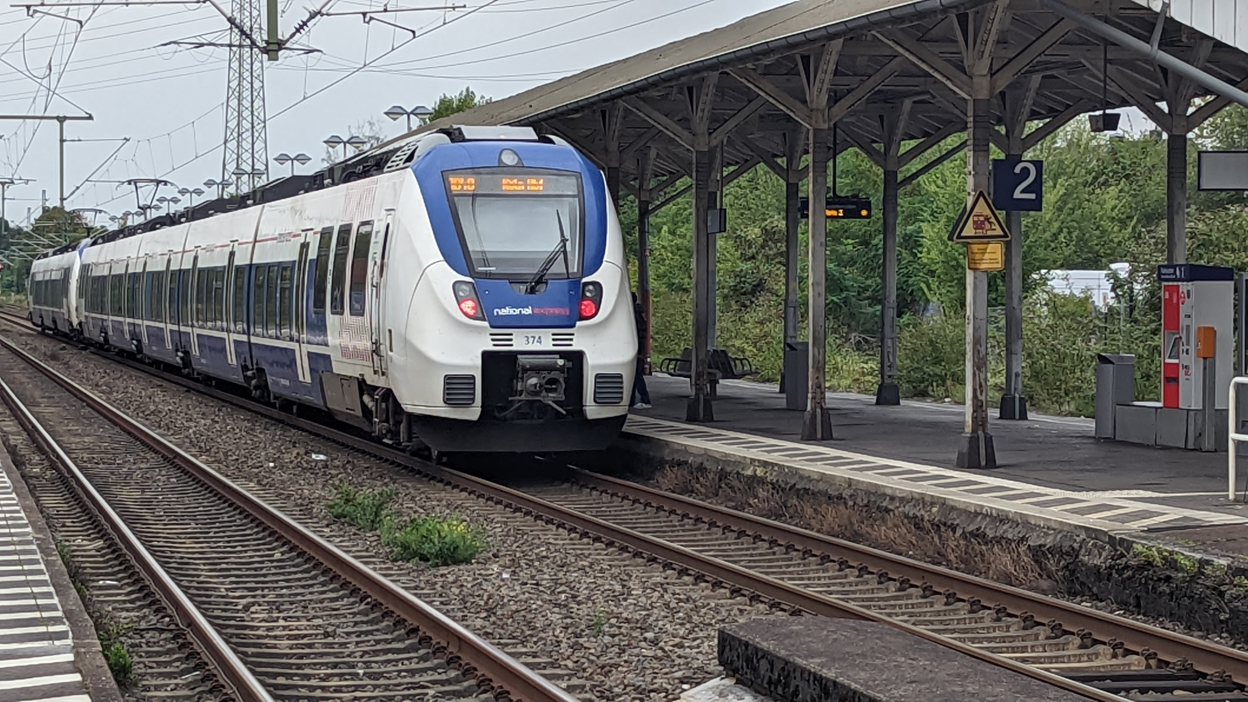 Der Zug steht an Gleis 2 vom Bahnhof Leverkusen-Manfort. Fahrgäste steigen ein und aus.